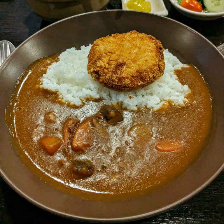 A savory bowl of Japanese curry with rice and crispy cutlet, perfect for comfort food enthusiasts.